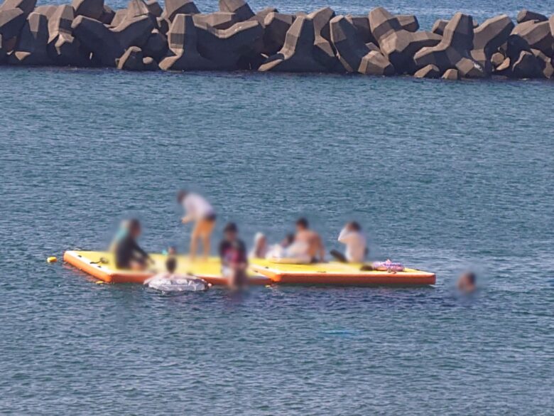 鷹巣海水浴場の海上休憩所（ボード）で楽しむ海水浴のひとたち