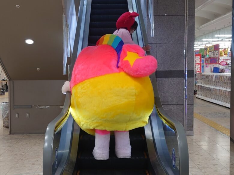 エスカレータに乗るプク丸ちゃんとかにこ隊長
